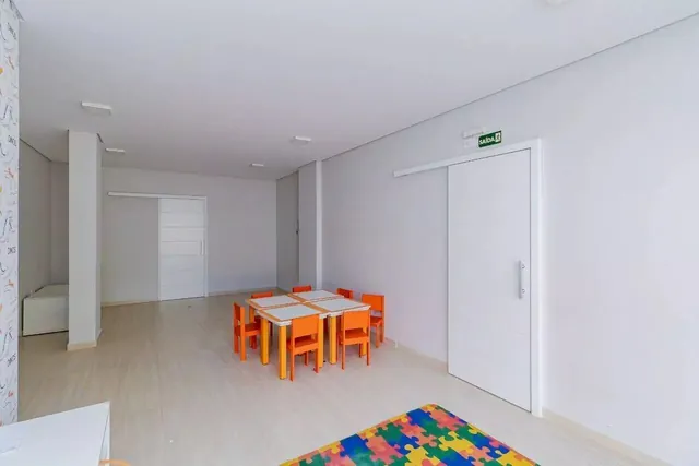 Brinquedoteca do Edifício Annecy, espaço kids coberto com mesas infantis